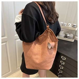 Macro shot of brown suede bucket bag texture with leather bell charm detail