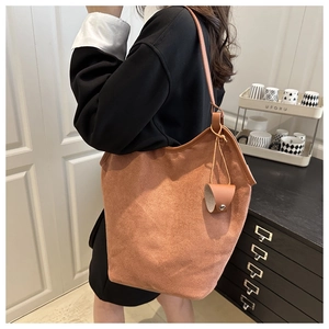 Detail of a brown suede oversized tote bag with matching side pouch accessory