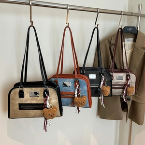 Sacs Boston rétro en quatre coloris avec porte-clés ours sur un présentoir épuré