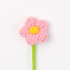 Dettaglio di un fiore rosa fatto a mano all'uncinetto con stame giallo e stelo verde