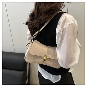 Close-up of beige patent leather shoulder bag with sleek gold capsule buckle detail