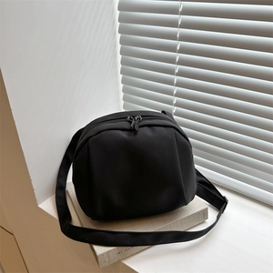 Minimalist black crescent crossbody bag with pleated nylon and adjustable wide strap