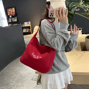 Sac seau en toile rouge tendance avec lettrage blanc artistique pour un style décontracté