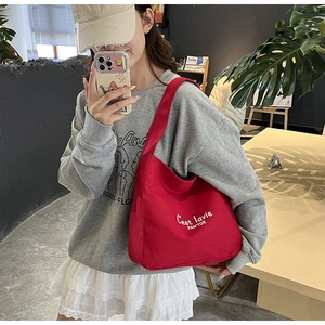 Mannequin portant un cabas en toile rouge avec l'inscription blanche C'est lavie