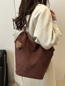 Grand sac cabas en daim marron foncé avec petite pochette assortie porté à l'épaule