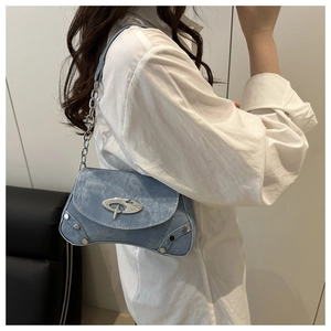 Detail of light blue denim shoulder bag with star logo and metallic chain strap