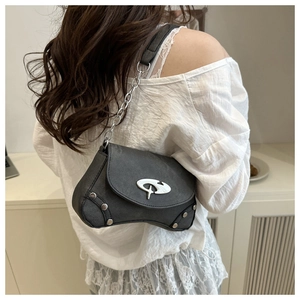 Detail of dark grey flap shoulder bag with silver chain strap and star metal emblem