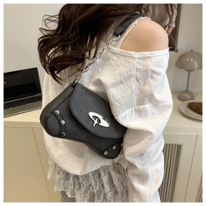 Detail of black half-moon shoulder bag with silver studs and geometric metal buckle