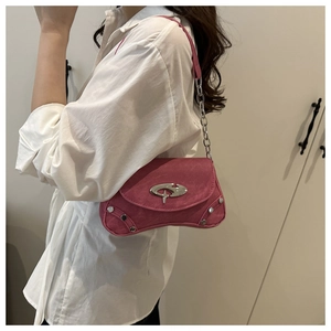 Close-up of pink suede underarm bag featuring silver metallic logo and rivet details