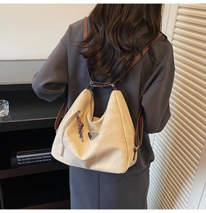 Detail of off-white matte dual-use tote bag featuring silver triangle buckle and leather strap