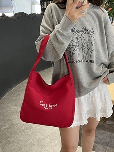 Sac fourre-tout en toile rouge avec lettrage blanc montré en selfie miroir