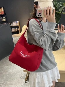 Sac fourre-tout en toile rouge avec broderie blanche dans un cadre de vie moderne