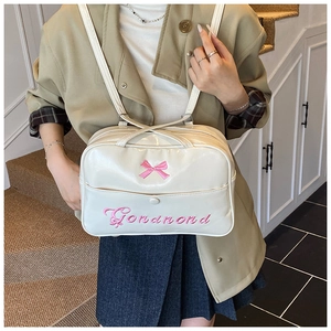 Detailansicht einer weißen PU-Leder Umhängetasche mit rosa Schleifenstickerei und Schultergurt