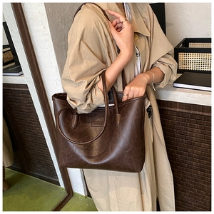 Detail of dark brown leather tote bag showing vintage texture and fashion logo