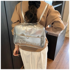 Detail der silbernen Metallic-Tasche mit Schleifenstickerei als Rucksack getragen