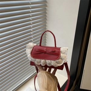 Rote Mini-Handtasche mit Schleife und Spitze auf einem Fensterbrett im Licht