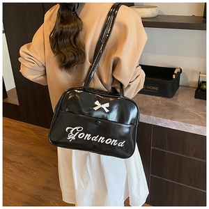 Black patent leather tote bag featuring a white bow detail and stylish embroidery