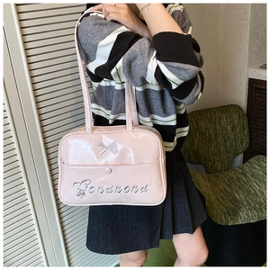 Detailaufnahme der glänzenden rosa Umhängetasche mit Silberschleife und Gonamond-Stickerei