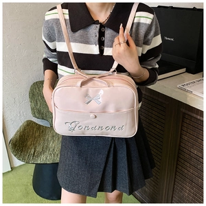 Detailed shot of pink glossy backpack with silver bow decoration and embroidery