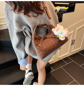 Détail du sac cabas léopard avec cordon de serrage et charm en peluche blanche