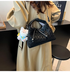 Détail du sac léopard avec poignée nouée et breloque ours en peluche rose