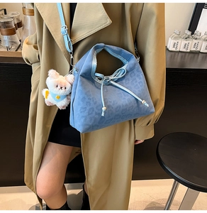 Détail du sac léopard bleu avec pendentif ours en peluche et fermeture à cordon coulissant