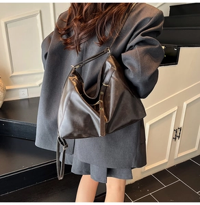 Close-up detail of the retro brown leather tote bag with metallic buckle and soft texture