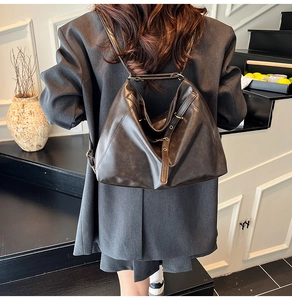 Lifestyle shot of woman wearing a vintage brown faux leather backpack with metallic accents