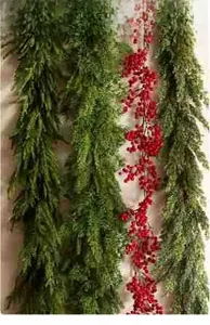 Detail view of Norfolk pine garland set with lifelike cedar branches and red berries