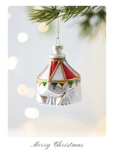 Detail of glass circus elephant ornament with festive flags hanging on a Christmas tree