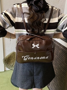 Brauner glänzender Rucksack mit weißer Schleife und Stickerei in der Rückansicht