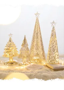 Detail of four champagne glass Christmas trees with warm LED lights on a white faux fur rug