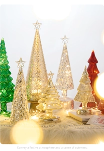 Macro shot of glass Christmas trees with LED warm lights on a soft white plush base