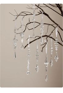 Detalle de gotas de hielo y copos de nieve de acrílico en ramas oscuras decorativas