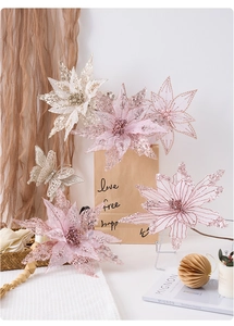 Detail of pink artificial Christmas poinsettia flowers with glitter and butterfly decor