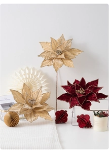 Vue détaillée de poinsettias en velours champagne et rouge avec bordure dorée élégante