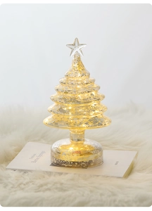 Detail of champagne mercury glass Christmas tree lamp with warm LED lights and star topper