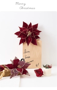 Détail de fleurs de poinsettia en velours avec paillettes et boules en papier alvéolé