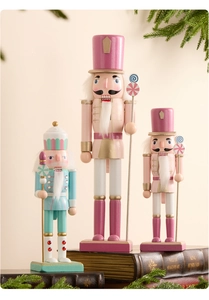 Dettaglio di tre schiaccianoci in legno color pastello su libri vintage