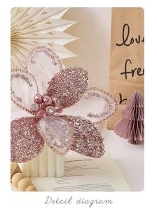 Detailed view of pink mesh Christmas flower with beads and rhinestones on book