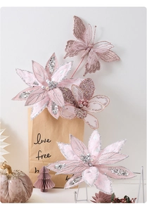 Close-up of pink artificial poinsettia and glitter butterfly for Christmas decor