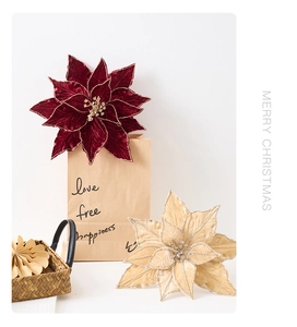 Détail de fleurs de poinsettia en velours rouge et champagne avec bords à paillettes fines
