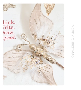 Close-up of champagne velvet butterfly with white feathers and gold glitter for Christmas decor