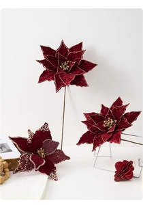 Détail de fleurs de poinsettia artificielles en velours rouge avec bords dorés