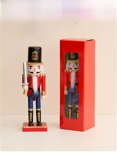Schiaccianoci soldato tradizionale in uniforme con la sua confezione regalo rossa festiva