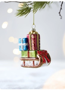 Detail of Christmas white sleigh ornament with colorful gift boxes on pine tree