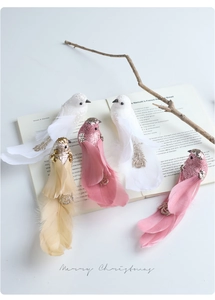 Close-up of decorative birds with sequins and real feathers on a rustic book