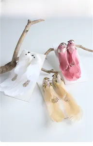 Detail view of glittery artificial birds with feather tails for Christmas decorations