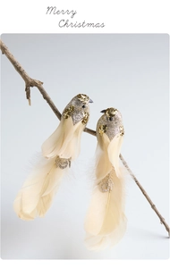 Close-up of sparkling Christmas bird ornaments with real feathers on a branch