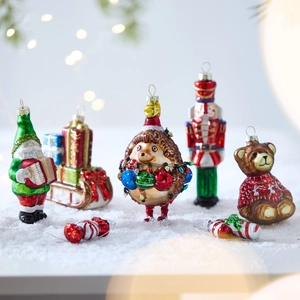 Set of 7 painted glass Christmas ornaments including Santa and Nutcracker on white snow
